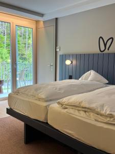 因特拉肯HOP Apartments & Suites的带阳台的卧室内的一张大床