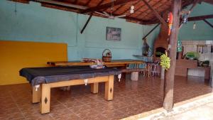 a room with wooden tables and a kitchen with a tableablish at Pousada Rural Ouro Verde in Eldorado