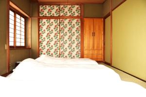 a bedroom with two beds and a floral curtain at Traditional Japanese House -in Matsumoto Asama Onsen- in Matsumoto