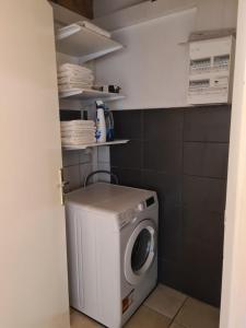 a washer and dryer in a small bathroom at La maison d'antan in La Longeville