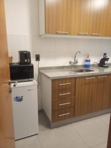 a kitchen with a sink and a microwave and a refrigerator at Cazartes in Treinta y Tres +3 photos