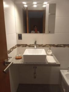 a man taking a picture of a sink in a bathroom at Cazartes in Treinta y Tres