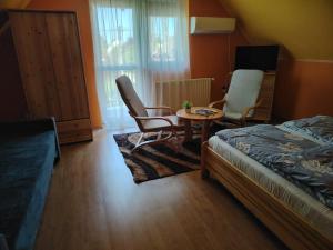 a bedroom with a bed and a table and chairs at Silye Vendégház in Hortobágy