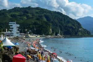 una spiaggia con un mucchio di ombrelloni e gente sopra di FOX Orbi Resort Hotel a Itʼkhvisi