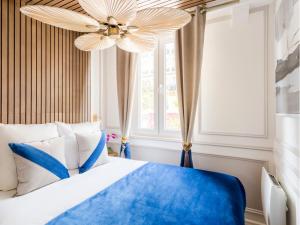Un dormitorio con una cama azul y una lámpara de araña. en Merveil - Luxury Suite - Notre Dame - Monge, en París