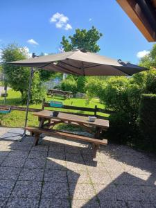 a picnic table with an umbrella on a patio at Unisotel GAP -" Ex HôtelF1" in Gap