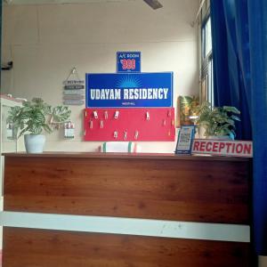 a wooden counter with signs on top of it at Udayam Residency in Kozhikode