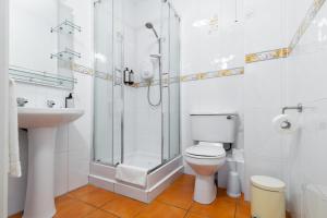 a bathroom with a shower and a toilet and a sink at Gort Na Coiribe - Galway Lakeside Apartments in Galway +2 photos