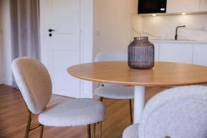 a table with chairs and a vase on top of it at Apt Liberation - Apt standing Centre Tourrettes sur Loup in Tourrettes-sur-Loup