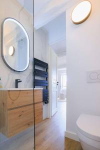 a bathroom with a toilet and a mirror on the wall at Apt Liberation - Apt standing Centre Tourrettes sur Loup in Tourrettes-sur-Loup