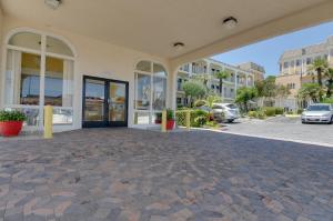 un edificio con una gran puerta de cristal en un aparcamiento en Vagabond Inn San Pedro en San Pedro