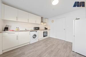 a kitchen with white cabinets and a washer and dryer at 3BR Home in Kilmarnock Sleeps 6 in Kilmarnock