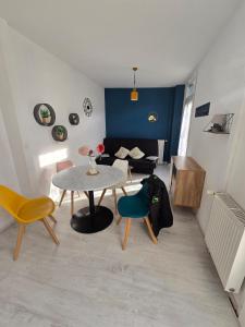 a living room with a table and chairs and a couch at Appartement en RDC, lumineux et spacieux vue sur la montagne in La Bourboule