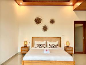 a bedroom with a large bed with two mirrors on the wall at Obah Villa Ubud 1 Br Brand new private villa in Ubud