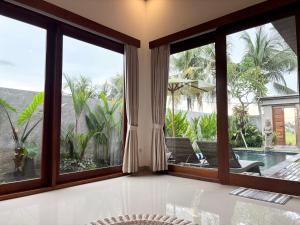 a room with large windows looking out onto a pool at Obah Villa Ubud 1 Br Brand new private villa in Ubud