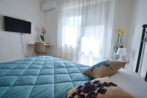 a bedroom with a blue bed and a window at Albergo Ristorante Locanda Rosella in Giba +65 photos