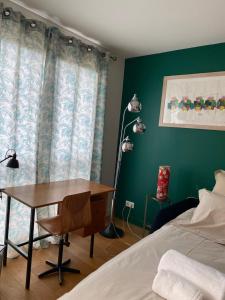 a bedroom with a desk and a bed and a lamp at Cosy et Arty in Paris