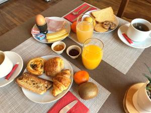 a table topped with plates of breakfast foods and orange juice at Logis Hôtel Le Saint Florent in Mont-près-Chambord