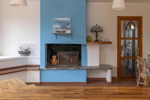 a fireplace in a living room with a blue wall at Villa Bonaccia - YourPlace Abruzzo in Ortona