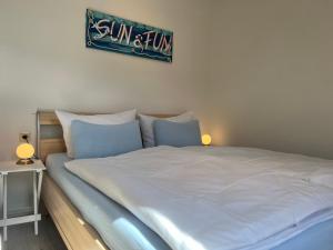 a large white bed with a sign on the wall at Küstenkoje Red Balkon und Hund willkommen in Prerow