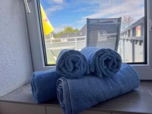 a pile of towels sitting next to a window at Küstenkoje Red Balkon und Hund willkommen in Prerow +4 photos