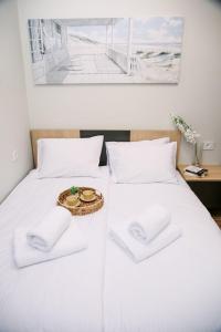 a white bed with two white pillows and a tray with a plate at POOL RESORT- Vila Lena- Apartman 2 in Vrdnik