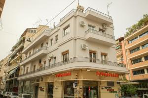 un alto edificio bianco con balcone di Mairas house collection ad Atene