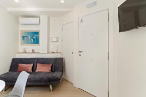 a living room with a black couch and a tv at Cala Luna-few steps from the beach in La Cala de Mijas