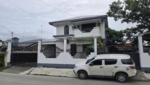 a white car parked in front of a white house at Jam Residences in Tagbilaran City