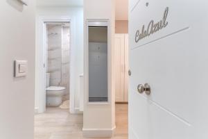 a bathroom with a toilet and a white door at Cala Azul-few steps from the beach in La Cala de Mijas +26 photos