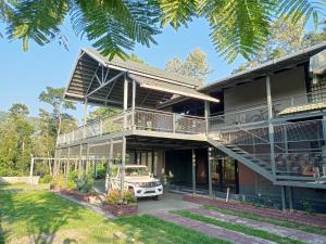 a house with a car parked in front of it at Hidden Haven 1BR Coorg in Kushālnagar