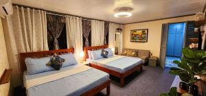 a hotel room with two beds and a window at Casa Bella Bacolod in Bacolod