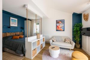 ein Schlafzimmer mit blauen Wänden und einem Bett und einer Couch in der Unterkunft Bontempo Village La Yole in Saint-Jean-de-Monts