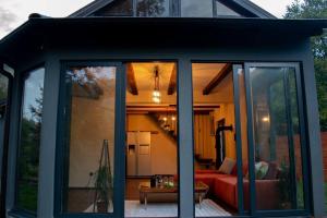 a glass extension of a house with a red couch at Funky House Sarajevo in Ilovice