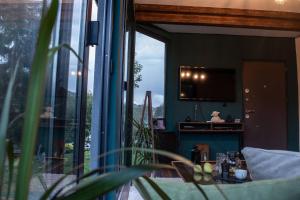 a living room with a large window and a tv at Funky House Sarajevo in Ilovice