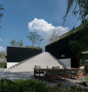 他朗Tree O'clock Pool Villa - Phuket的楼梯旁的天井配有桌椅
