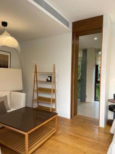 a living room with a table and a chair at Tree O'clock Pool Villa - Phuket in Thalang +133 photos