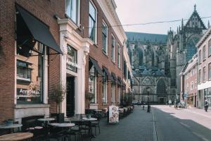 an empty street with tables and chairs and a cathedral at Anne&Max Boutique Hotel in Utrecht