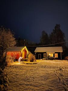 a house is lit up at night in front at 1850 Old Farmhouse Retreat with jacuzzi and sauna in Eidsvoll