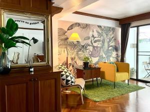 a living room with a yellow chair and a table at Pannarai's House in Bangkok +35 photos