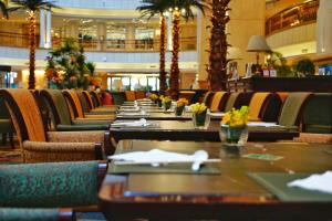 a long row of tables and chairs in a restaurant at Grand Central Hotel Shanghai - Nanjing Road in Shanghai