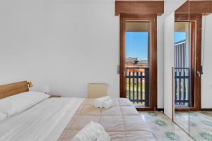 a bedroom with a large bed and a balcony at 200mt Lake - Flower Home with Pool & Tennis in Peschiera del Garda