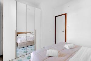 a white bedroom with a mirror and a bed at 200mt Lake - Flower Home with Pool & Tennis in Peschiera del Garda +28 photos