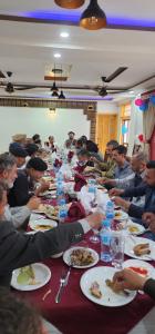 a group of people sitting at a long table eating food at Dream Palace Hotel Rakaposhi Nagar in Gilgit