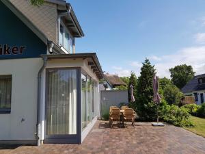 a patio with chairs and a sliding glass door at Exkl FH Quäkenpüker, Kamin, W-LAN in Börgerende-Rethwisch