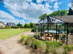 a greenhouse with a tub in a yard at Morning Glory, Huisje vogelzang in Beekbergen