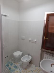 Un baño blanco con inodoro y lavabo. en Da Zio Antonio, en Agerola
