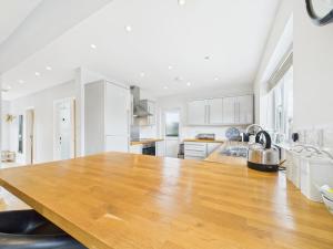 a kitchen with a large wooden table in a room at Delabere Road Bishops Cleeve Free Parking WiFi in Bishops Cleeve