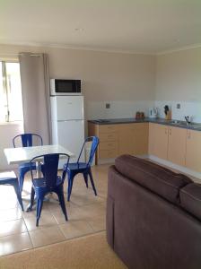 a living room with a couch and a table and a kitchen at Lake Barra Cottages in Downsfield