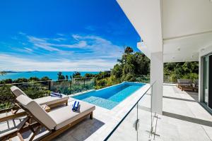 einen Meerblick vom Balkon eines Hauses mit Pool in der Unterkunft CoralAir Whitsundays in Airlie Beach